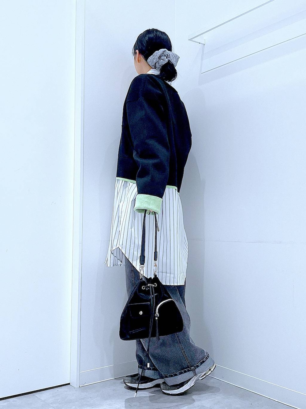 ブラック系のショルダーバッグ、ブラック系のデニムパンツ、ホワイト系のシャツ/ブラウスを着用したレディースの春コーディネートの3枚目の写真