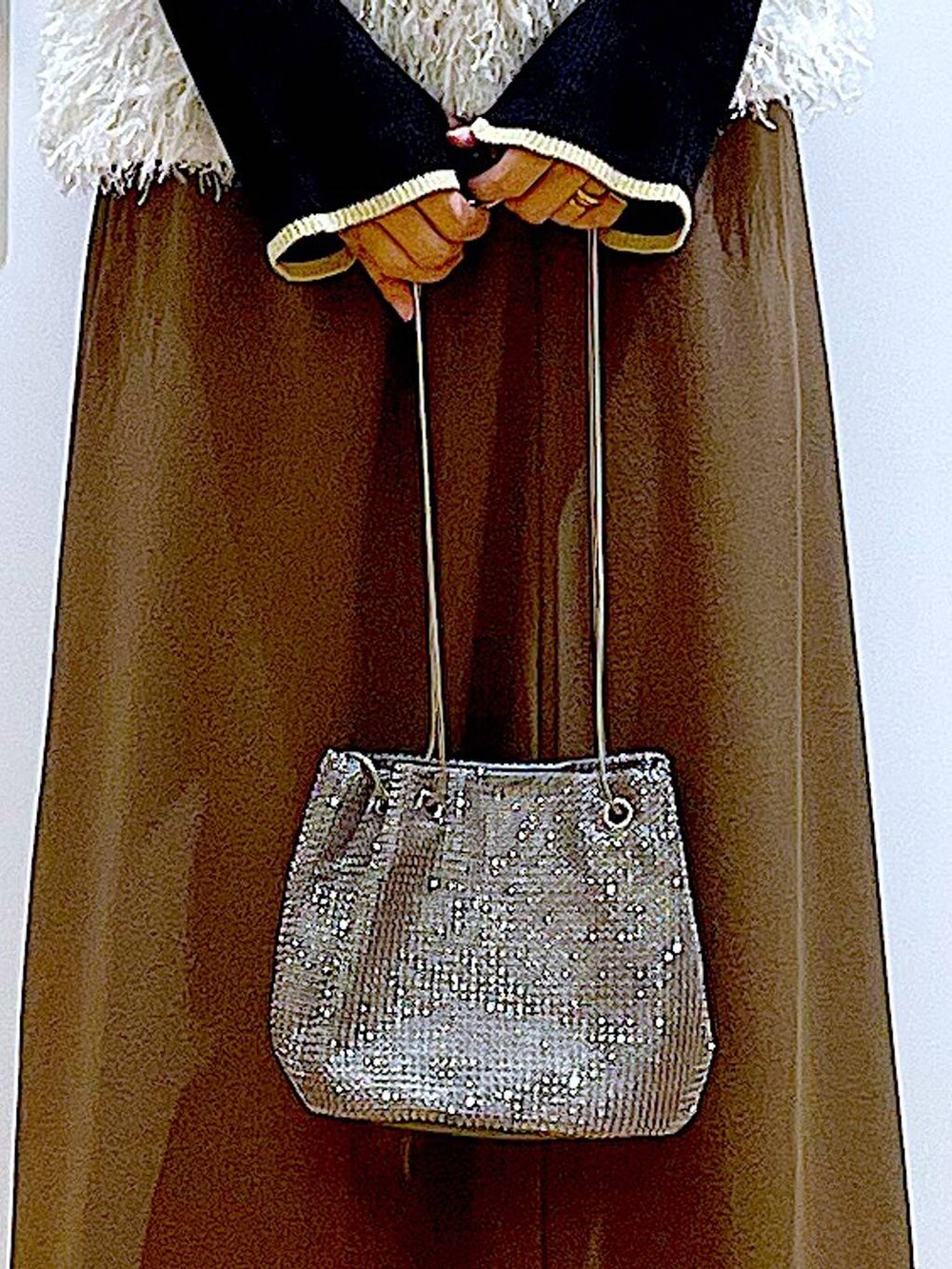 ブラック系のニット/セーター、グレー系のショルダーバッグ、ベージュ系のベストを着用したレディースの秋コーディネートの9枚目の写真