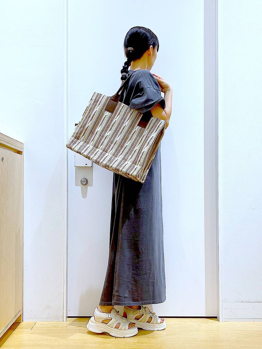 ホワイト系のサンダル、ブラウン系のトートバッグ、グレー系のワンピースを着用したレディースの夏コーディネートの4枚目の写真