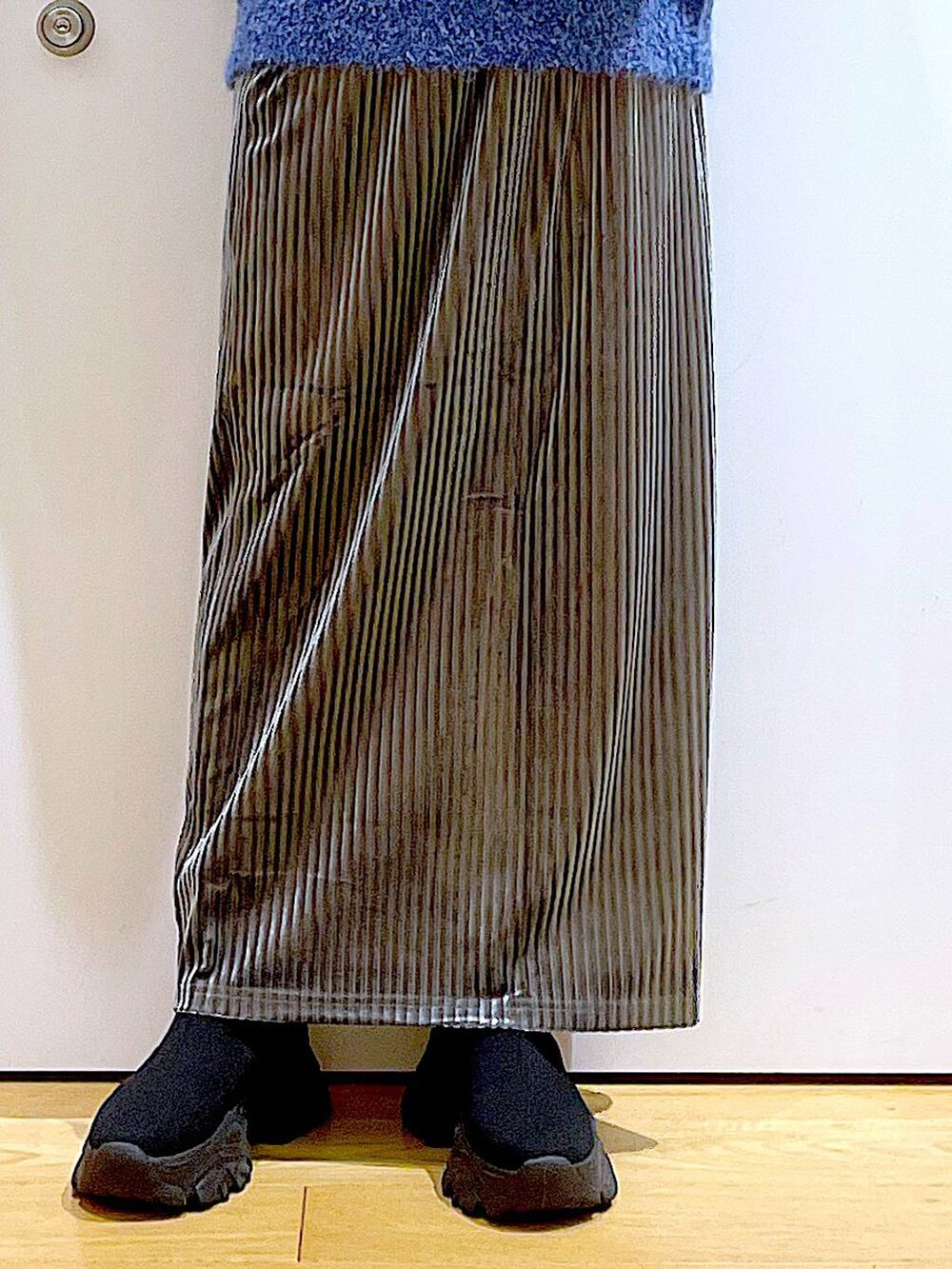 ブラック系のバックパック/リュック、グレー系のスカート、ブラック系のブーツを着用したレディースの冬コーディネートの8枚目の写真