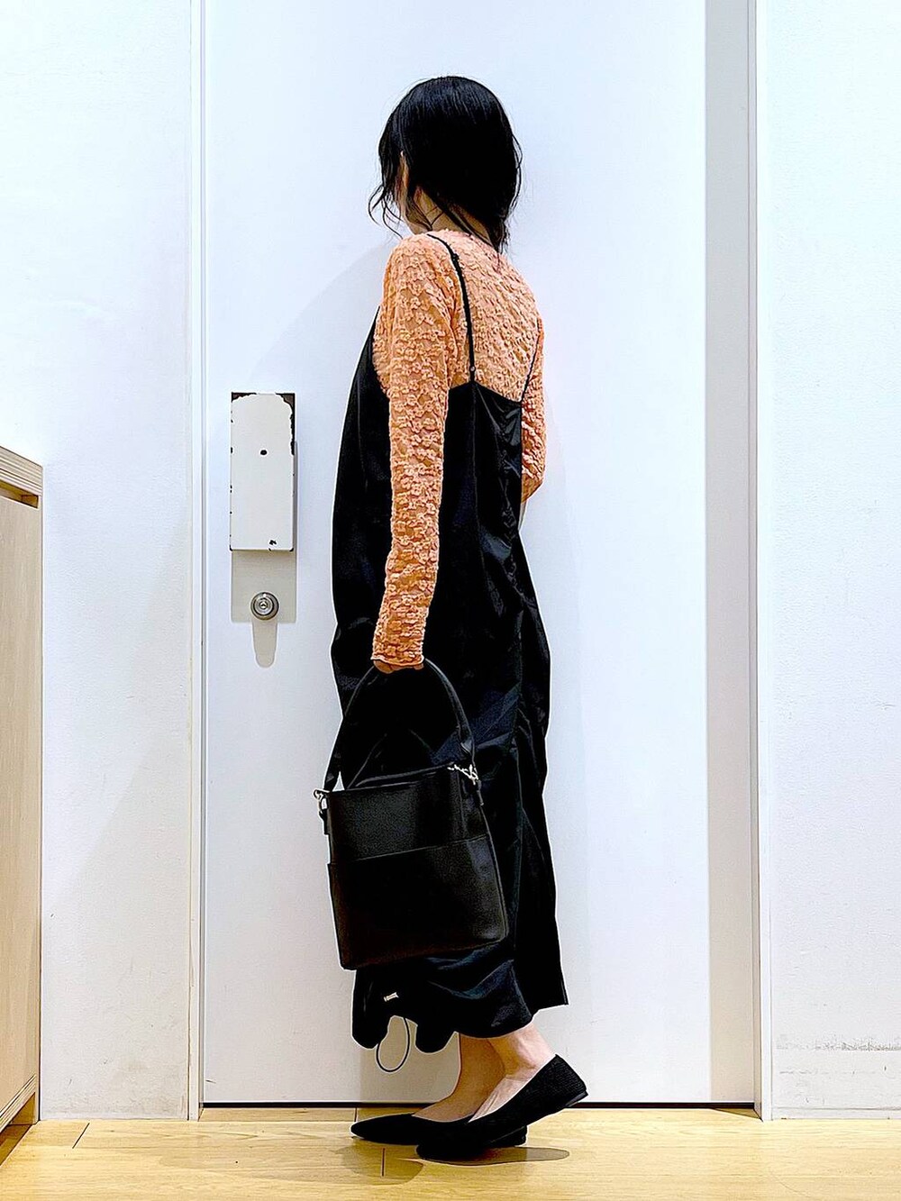 ブラック系のワンピース、ブラック系のショルダーバッグ、ブラック系のパンプスを着用したレディースの春コーディネートの3枚目の写真