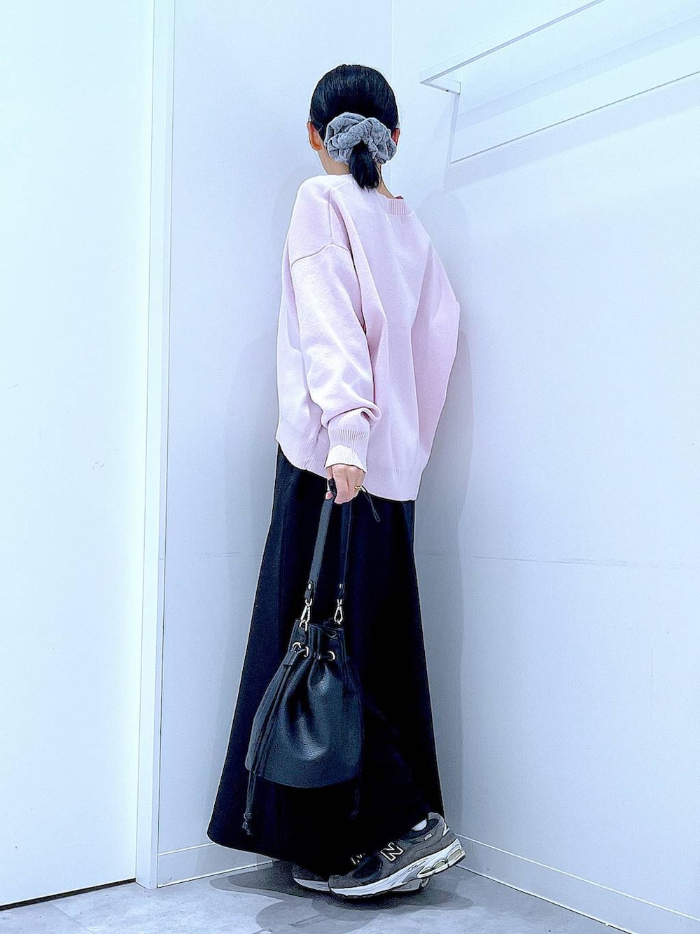 ピンク系のニット/セーター、ブラック系のショルダーバッグ、ブラック系のスカートを着用したレディースの春コーディネートの3枚目の写真