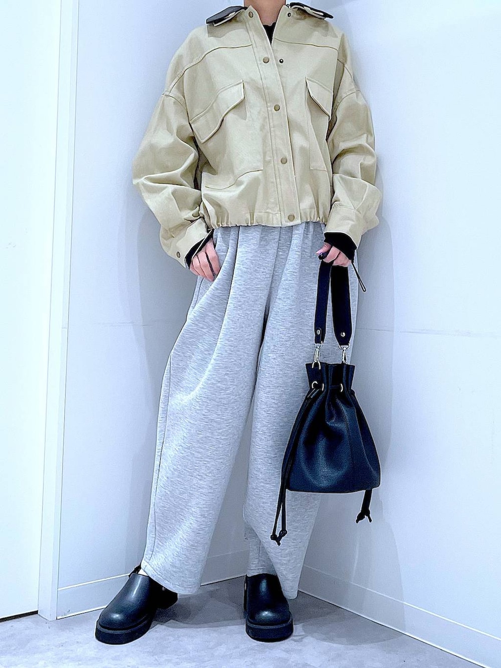 ブラック系のサンダル、ブラック系のショルダーバッグ、ベージュ系のブルゾンを着用したレディースの春コーディネートの6枚目の写真