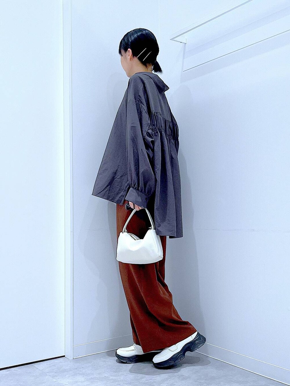 ホワイト系のローファー、ホワイト系のショルダーバッグ、ブラウン系のその他パンツを着用したレディースの秋コーディネートの3枚目の写真