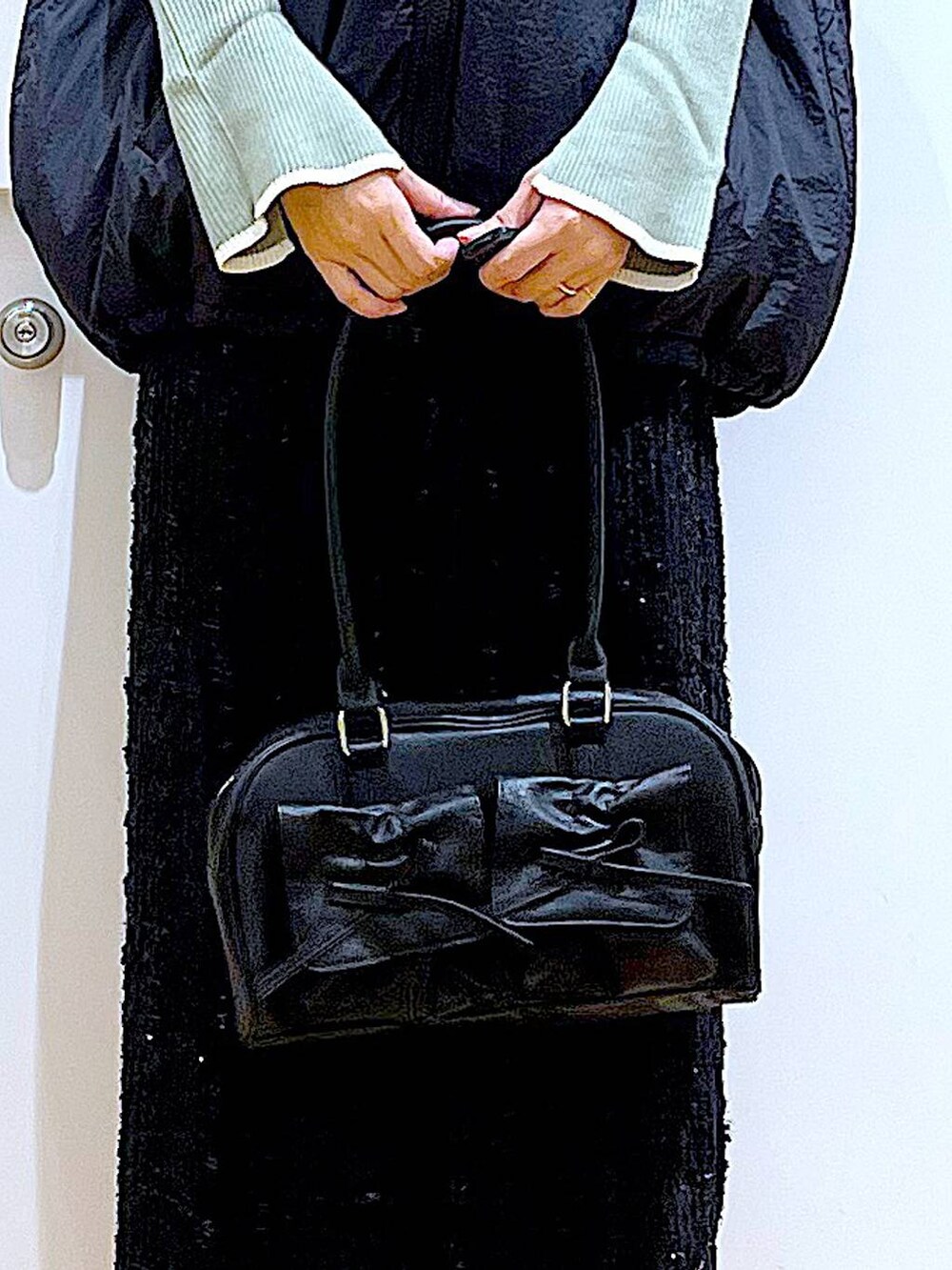 グリーン系のニット/セーター、ブラック系のハンドバッグ、ブラック系のブーツを着用したレディースの秋コーディネートの9枚目の写真