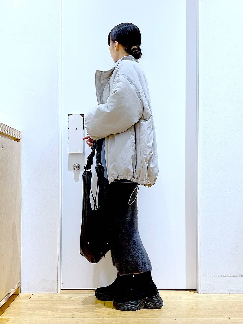 ブラック系のブーツ、ブルー系のスウェット、ブラック系のショルダーバッグを着用したレディースの冬コーディネートの3枚目の写真