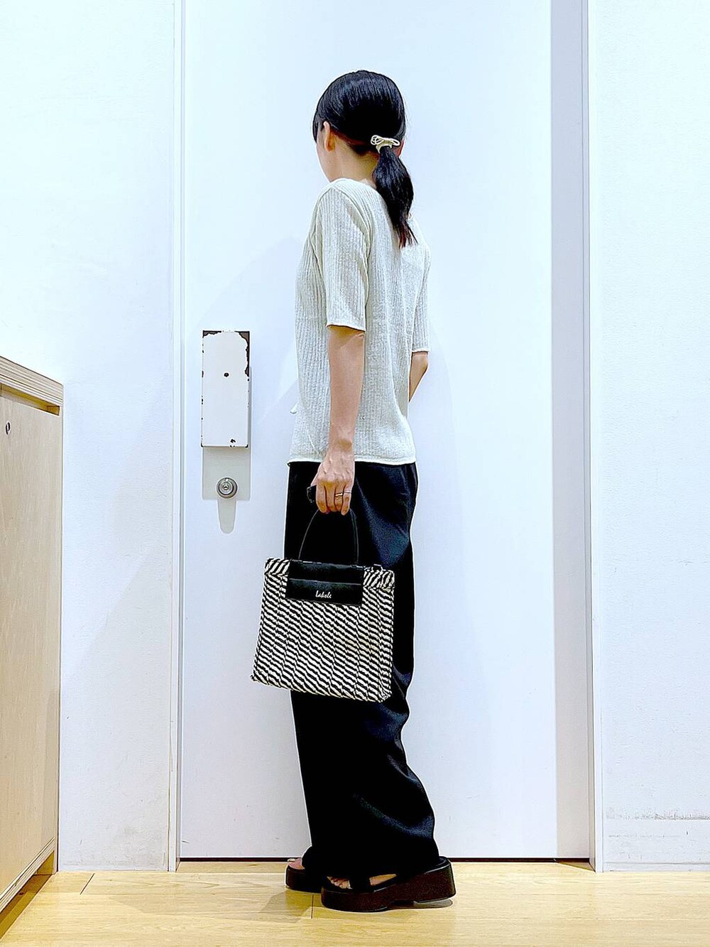 ブラック系のキャミソール、ブラック系のショルダーバッグ、ブラック系のサンダルを着用したレディースの夏コーディネートの3枚目の写真