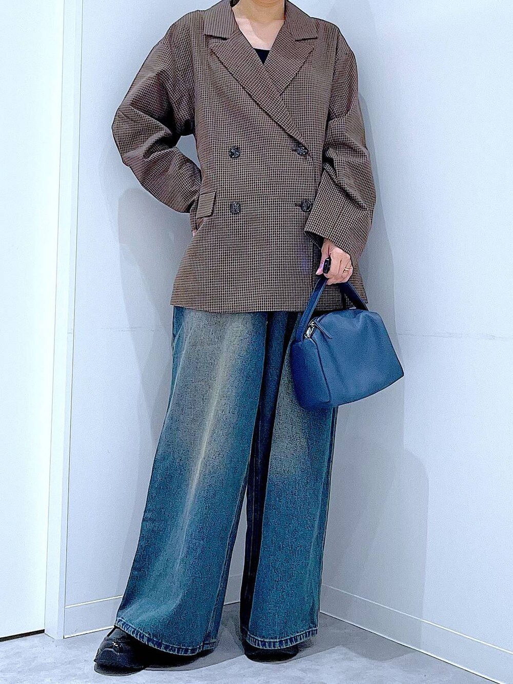 ブラック系のローファー、ブルー系のショルダーバッグ、ブルー系のデニムパンツを着用したレディースの秋コーディネートの6枚目の写真