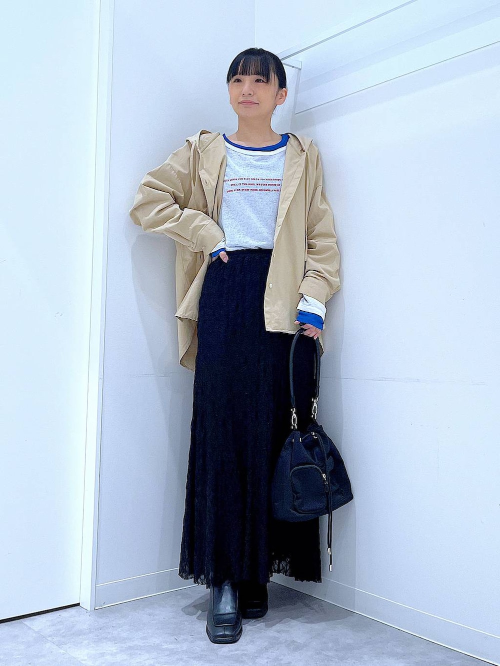 ブルー系のTシャツ/カットソー、ブラック系のブーツ、ベージュ系のその他トップスを着用したレディースの春コーディネートの2枚目の写真