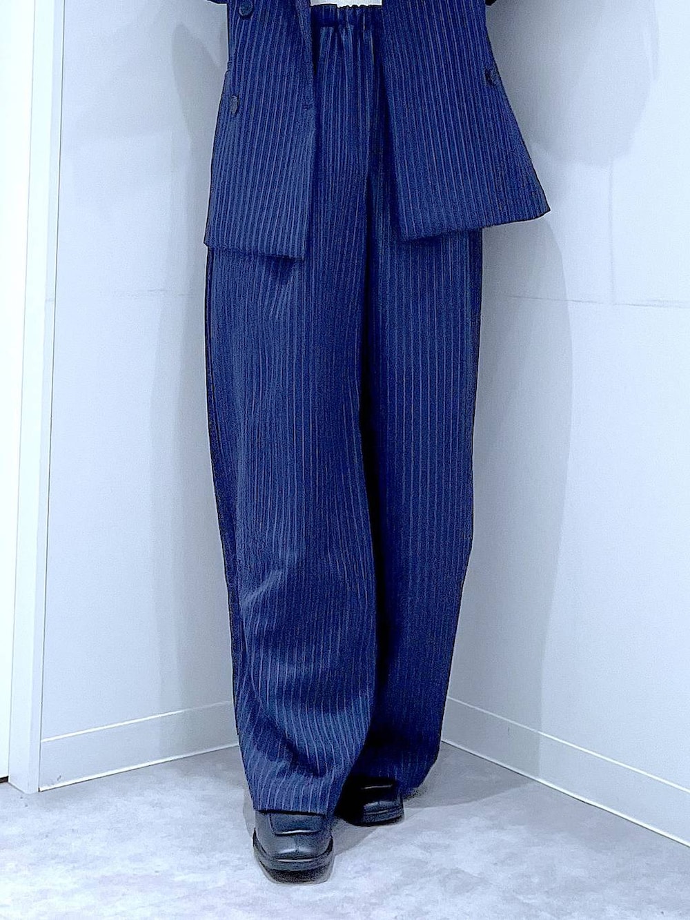 ブラック系のブーツ、ブラック系のショルダーバッグ、ブルー系のスラックスを着用したレディースの冬コーディネートの8枚目の写真