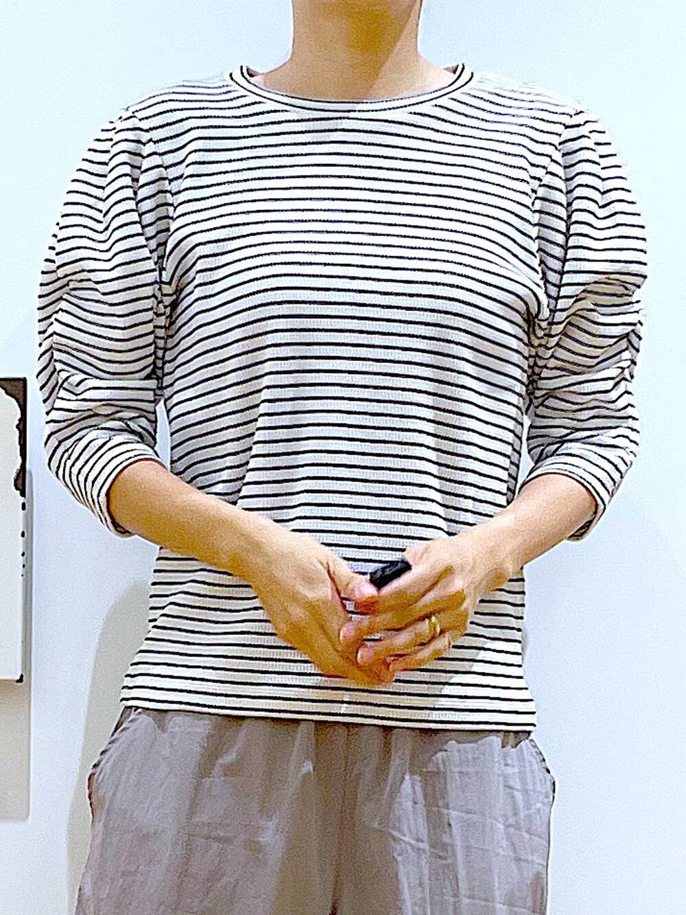 ホワイト系のハンドバッグ、シルバー系のパンプス、グレー系のその他パンツを着用したレディースの秋コーディネートの7枚目の写真