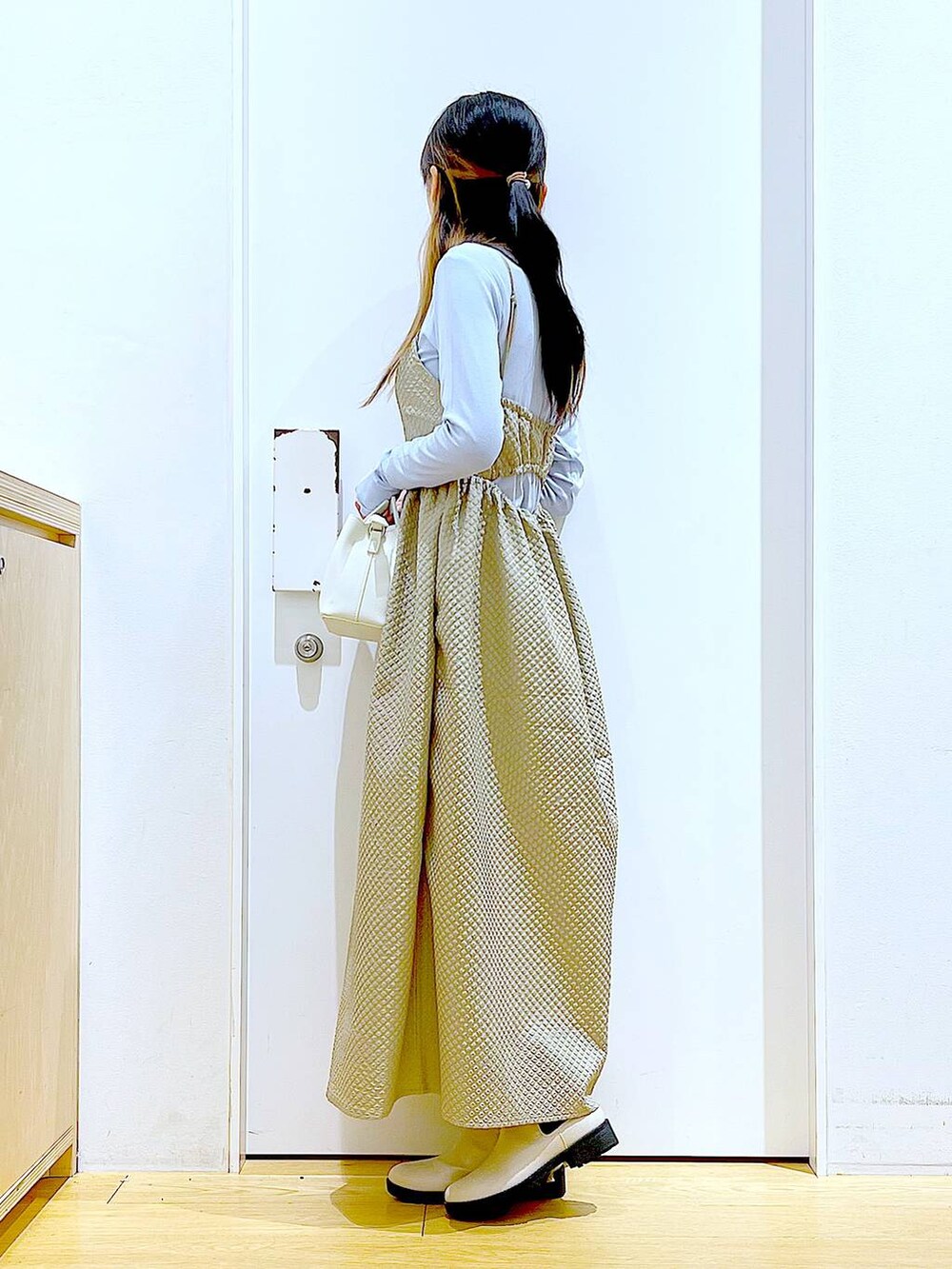 ブルー系のTシャツ/カットソー、ブラウン系のワンピース、ベージュ系のブーツを着用したレディースの冬コーディネートの3枚目の写真