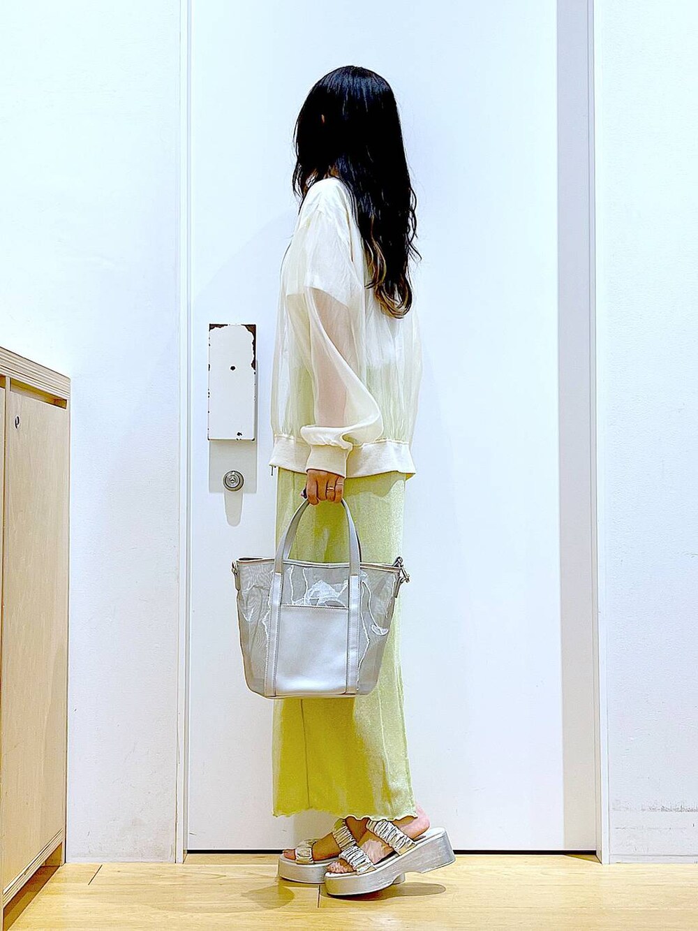 グリーン系のスカート、シルバー系のサンダル、シルバー系のトートバッグを着用したレディースの夏コーディネートの3枚目の写真
