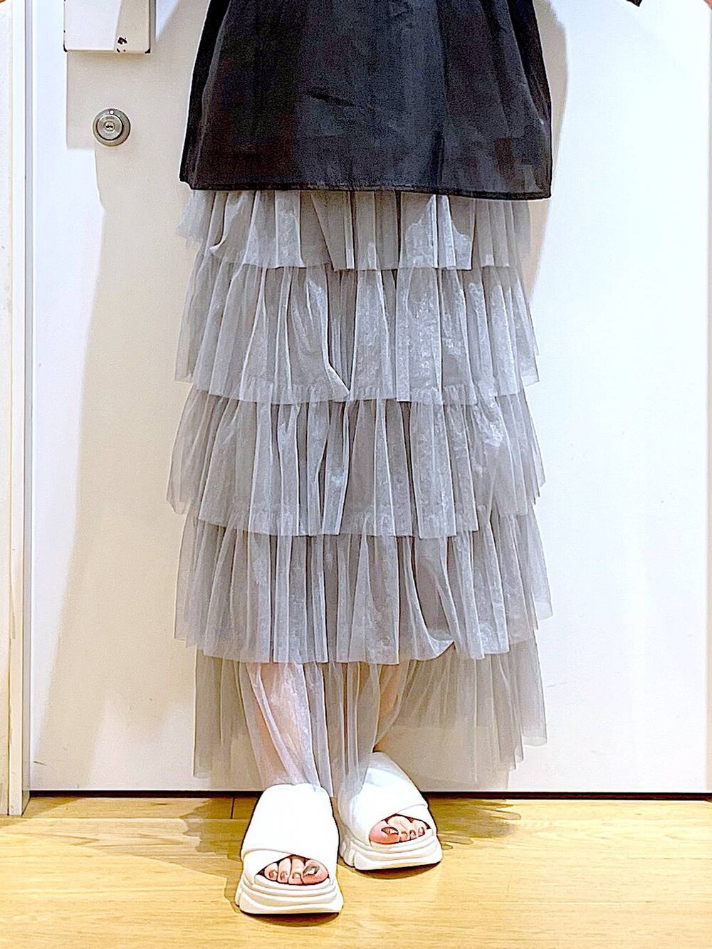 ホワイト系のサンダル、ブラック系のニット/セーター、ホワイト系のショルダーバッグを着用したレディースの夏コーディネートの8枚目の写真