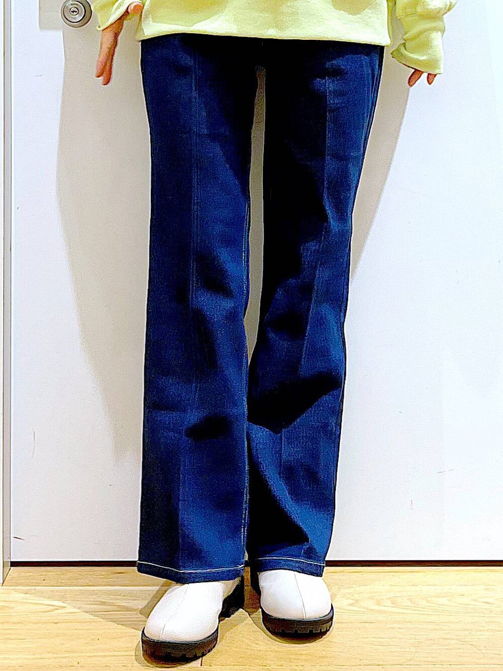 ブルー系のデニムパンツ、イエロー系のスウェット、ベージュ系のブーツを着用したレディースの冬コーディネートの8枚目の写真