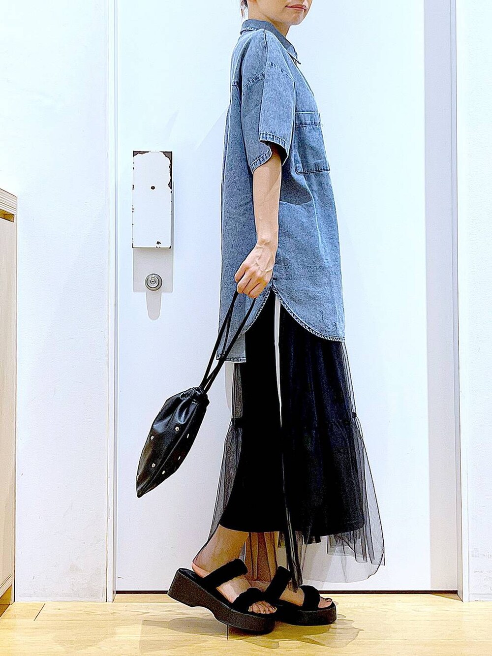 ブラック系のサンダル、ブラック系のショルダーバッグ、ブルー系のシャツ/ブラウスを着用したレディースの夏コーディネートの4枚目の写真