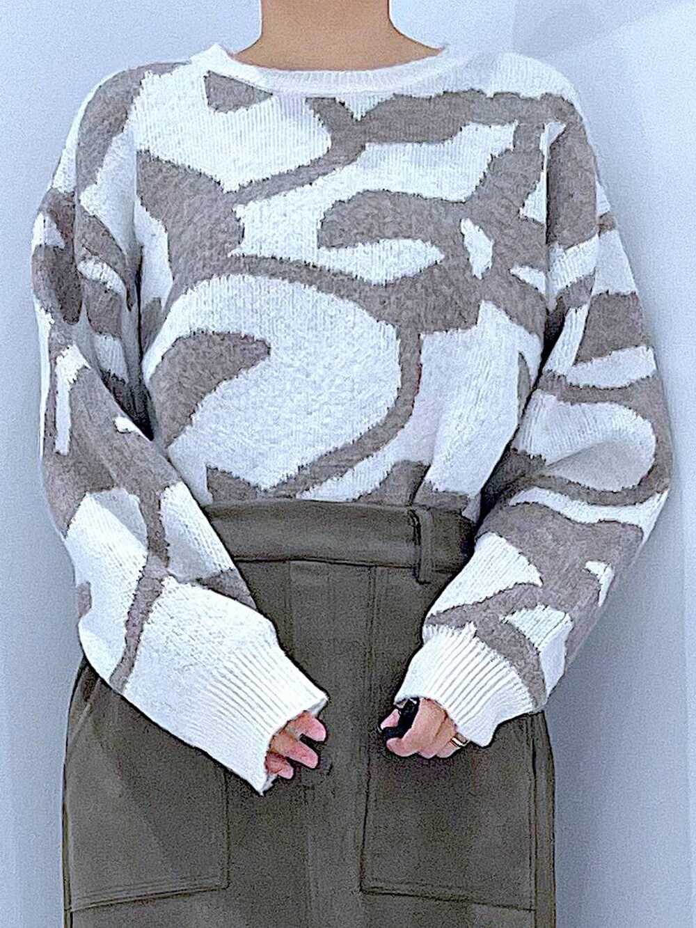 ブラック系のブーツ、ホワイト系のハンドバッグ、グリーン系のスカートを着用したレディースの秋コーディネートの7枚目の写真