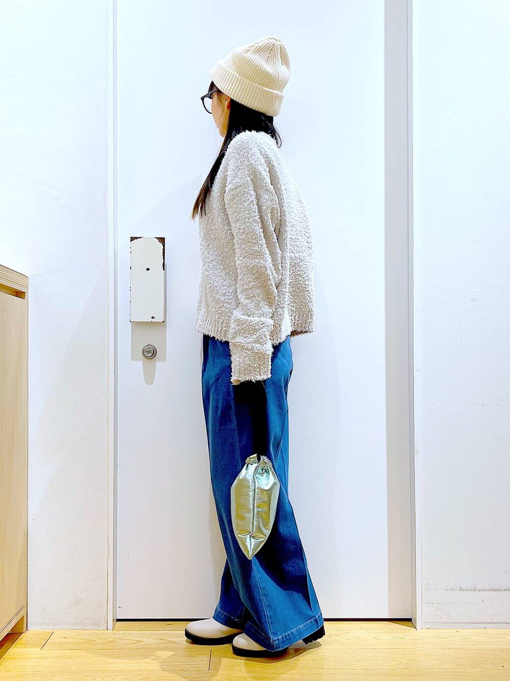 グレー系のニット/セーター、ブルー系のデニムパンツ、ベージュ系のブーツを着用したレディースの冬コーディネートの3枚目の写真