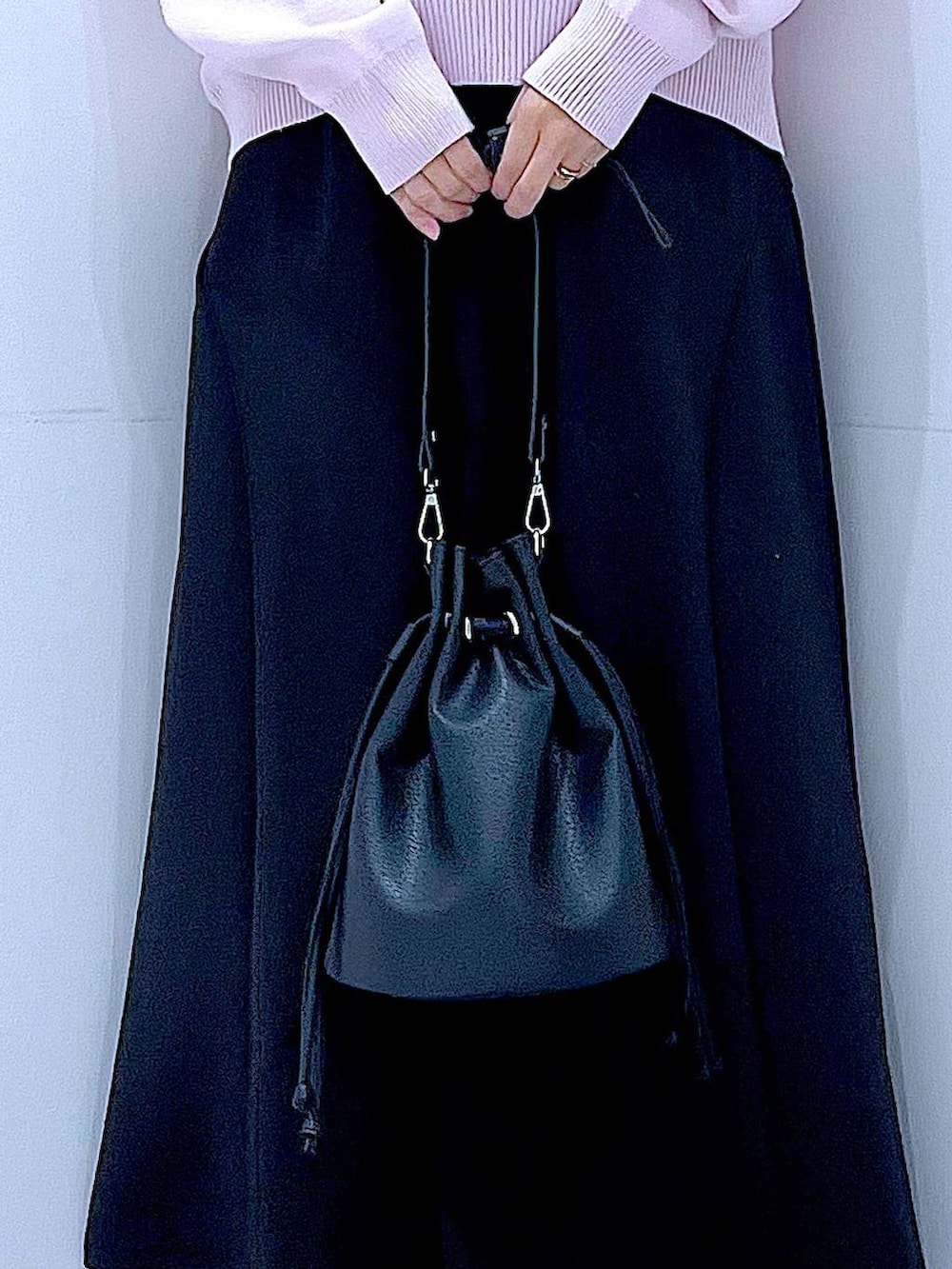 ピンク系のニット/セーター、ブラック系のショルダーバッグ、ブラック系のスカートを着用したレディースの春コーディネートの9枚目の写真