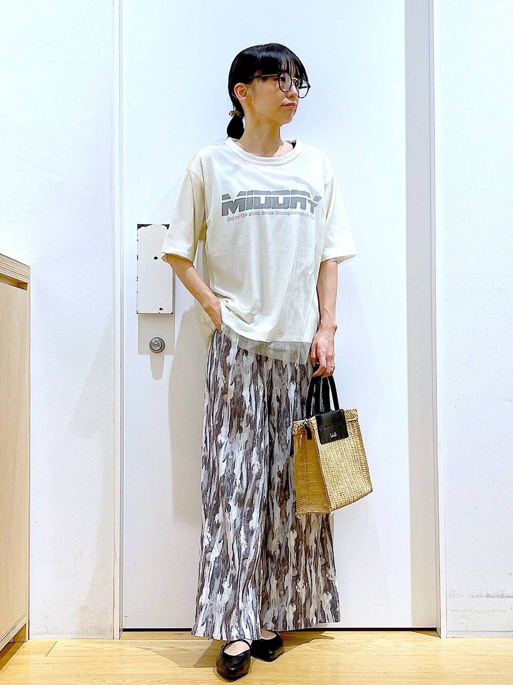 ホワイト系のTシャツ/カットソー、ブラック系のパンプス、ベージュ系のショルダーバッグを着用したレディースの夏コーディネートの2枚目の写真