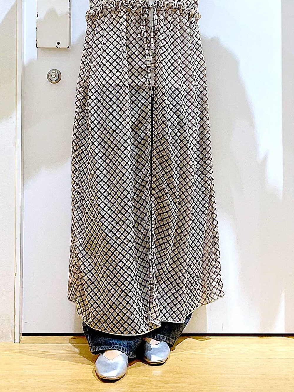 ブルー系のデニムパンツ、シルバー系のパンプス、ホワイト系のTシャツ/カットソーを着用したレディースの春コーディネートの8枚目の写真