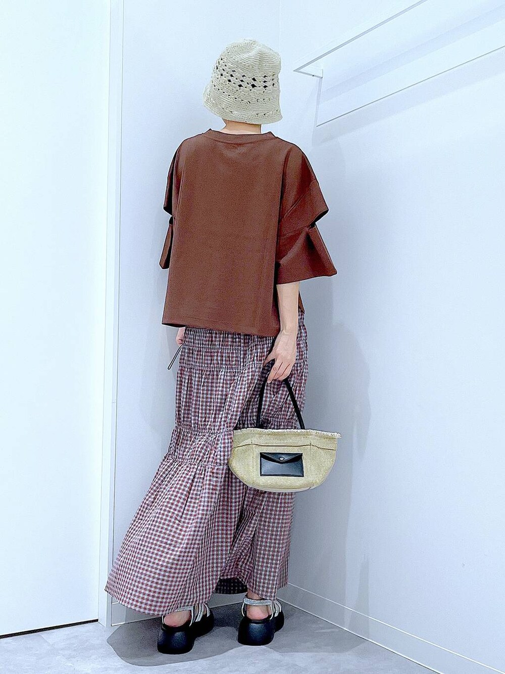 ベージュ系のショルダーバッグ、シルバー系のサンダル、ブラウン系のTシャツ/カットソーを着用したレディースの夏コーディネートの5枚目の写真