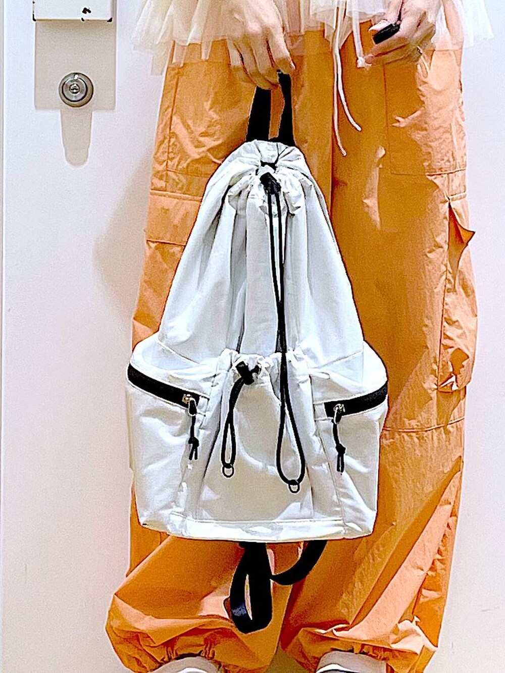 ホワイト系のスニーカー、ホワイト系のショルダーバッグ、オレンジ系のカーゴパンツを着用したレディースの夏コーディネートの8枚目の写真