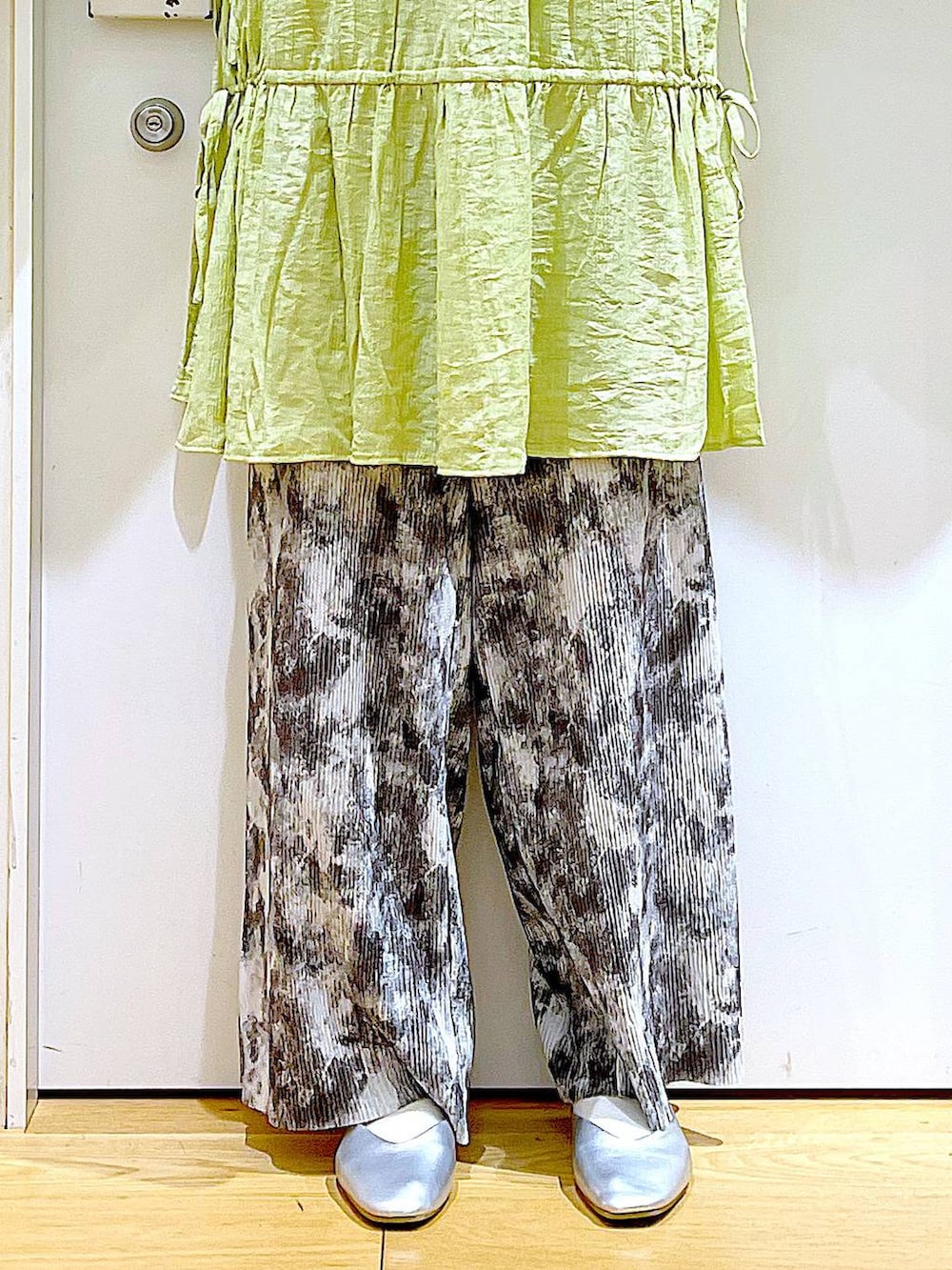 シルバー系のショルダーバッグ、シルバー系のパンプス、グリーン系のチュニックを着用したレディースの春コーディネートの8枚目の写真