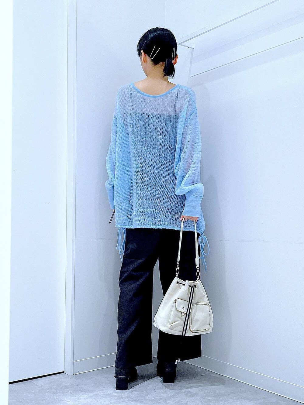 ブラック系のその他パンツ、ホワイト系のショルダーバッグ、ブラック系のブーツを着用したレディースの冬コーディネートの5枚目の写真