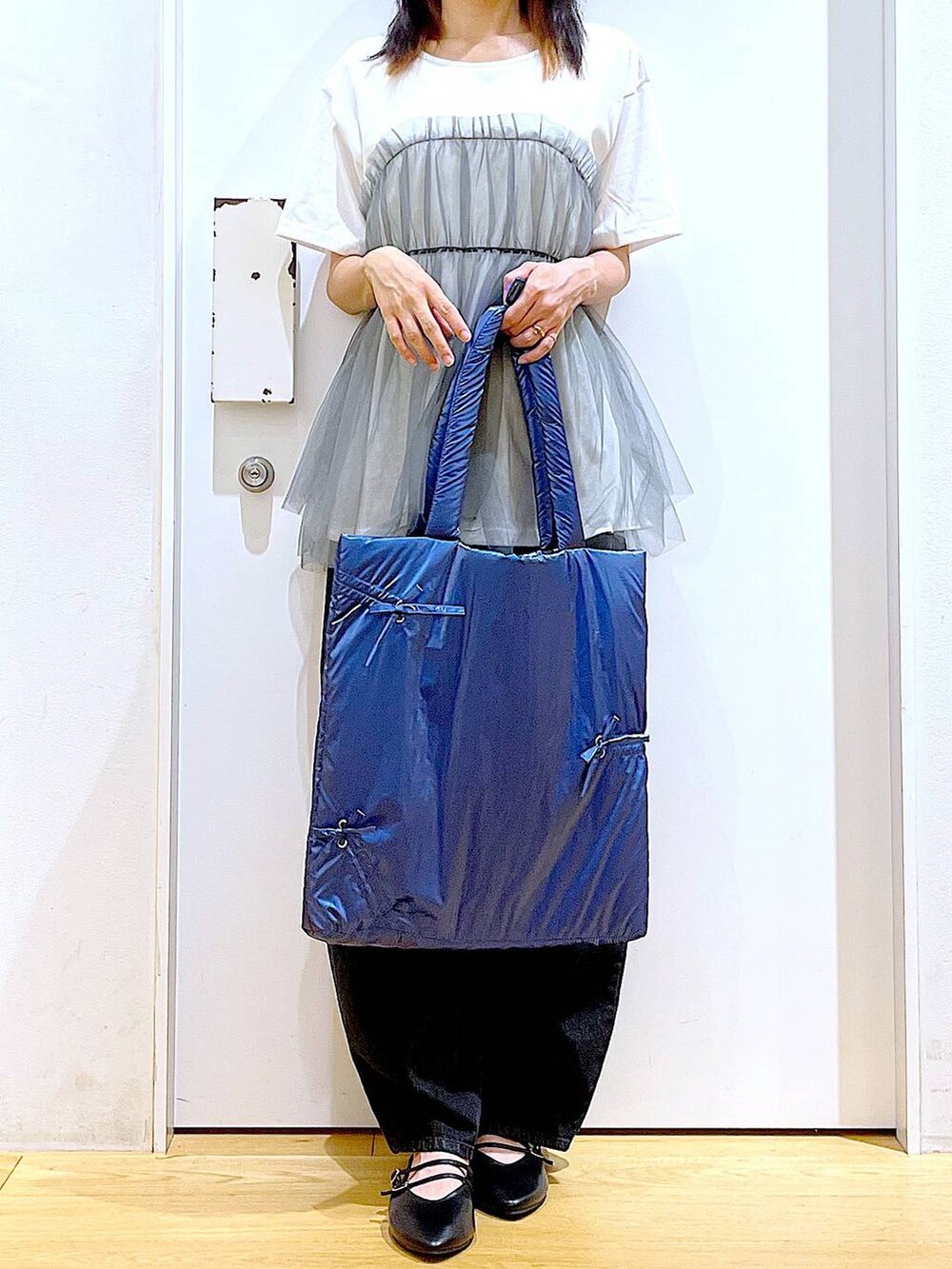 グレー系のTシャツ/カットソー、ブラック系のデニムパンツ、ブルー系のトートバッグを着用したレディースの秋コーディネートの6枚目の写真