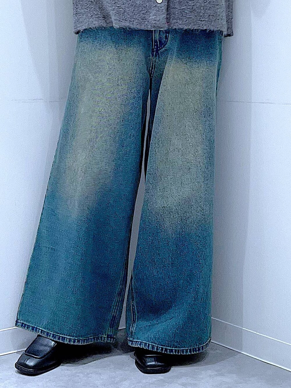 ブルー系のデニムパンツ、ブラック系のブーツ、ホワイト系のショルダーバッグを着用したレディースの冬コーディネートの8枚目の写真