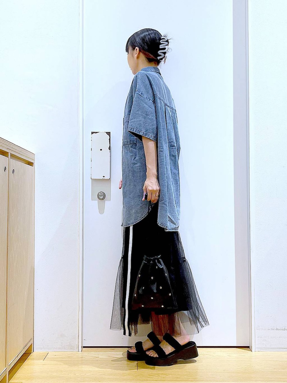 ブラック系のサンダル、ブラック系のショルダーバッグ、ブルー系のシャツ/ブラウスを着用したレディースの夏コーディネートの3枚目の写真