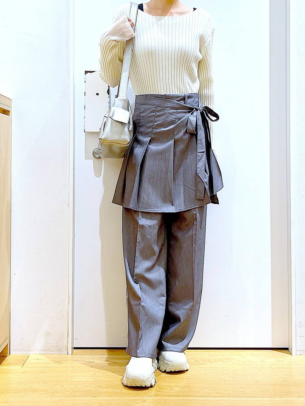 ホワイト系のニット/セーター、グレー系のスラックス、グレー系のスカートを着用したレディースの秋コーディネートの6枚目の写真