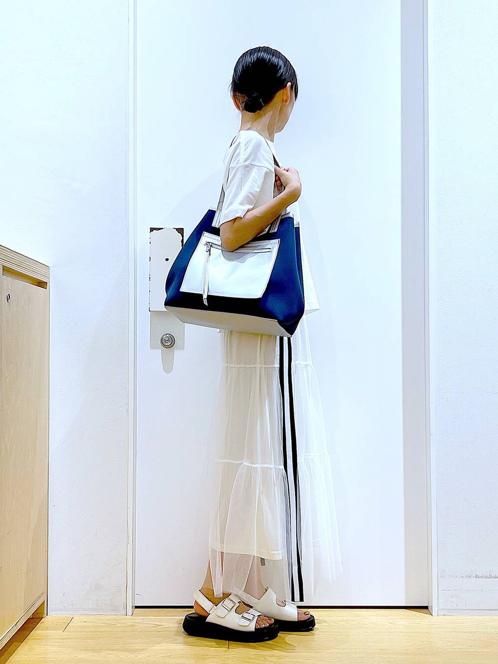 ホワイト系のサンダル、ホワイト系のスカート、ホワイト系のTシャツ/カットソーを着用したレディースの夏コーディネートの4枚目の写真