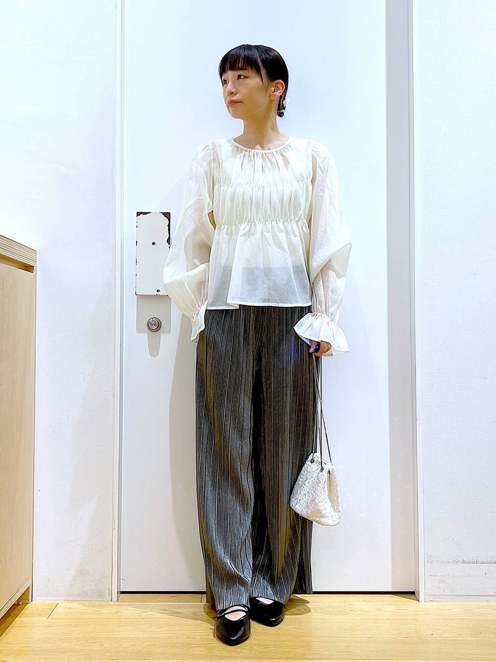 グレー系のその他パンツ、ブラック系のパンプス、ホワイト系のシャツ/ブラウスを着用したレディースの秋コーディネートの2枚目の写真