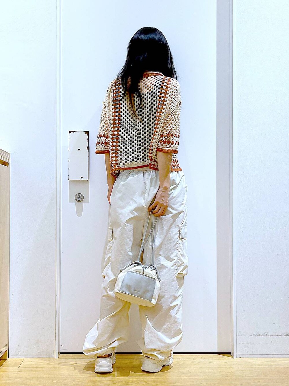 ホワイト系のショルダーバッグ、ホワイト系のカーゴパンツ、ホワイト系のサンダルを着用したレディースの夏コーディネートの5枚目の写真