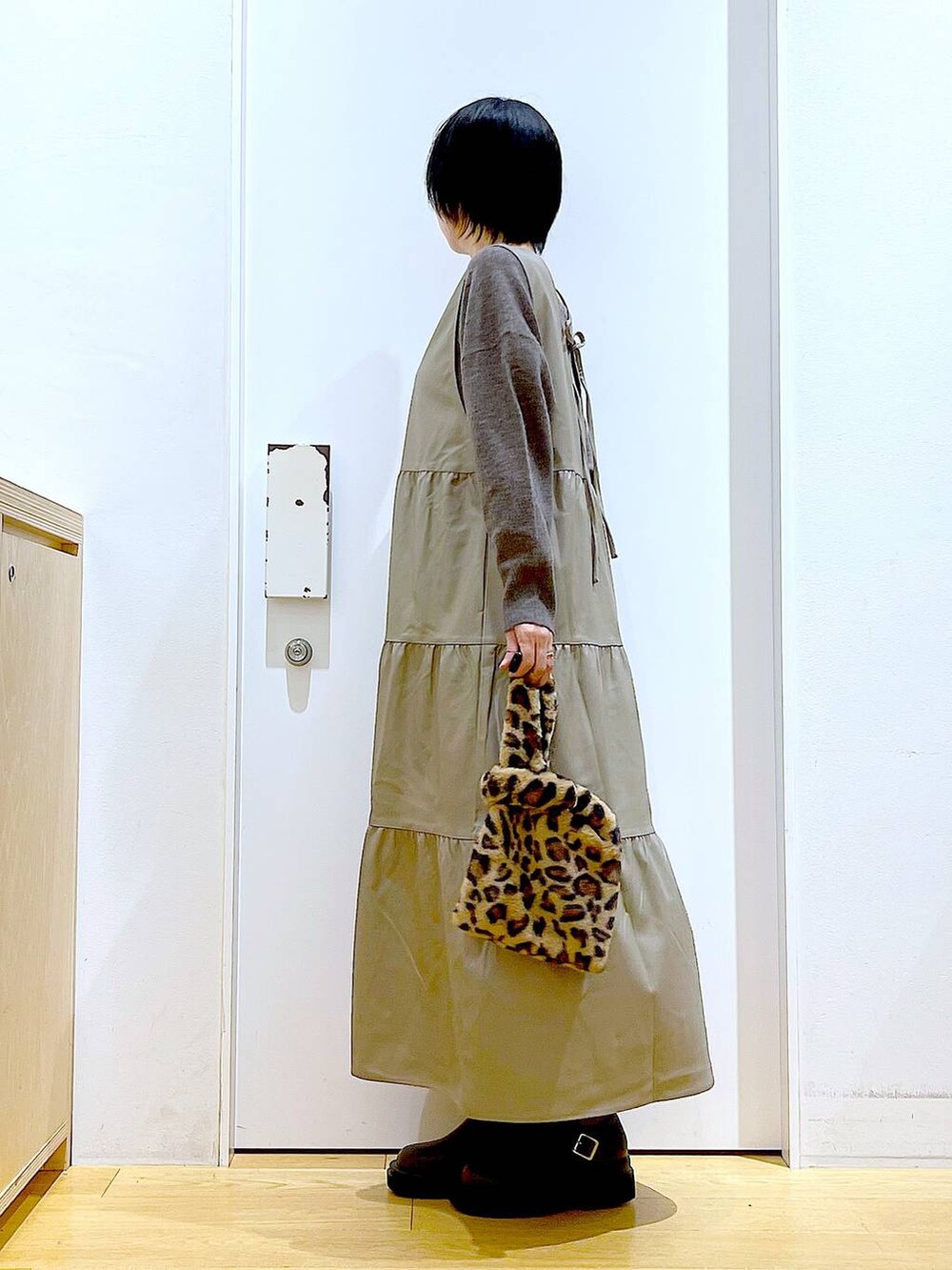 ブラウン系のニット/セーター、その他のショルダーバッグ、ブラウン系のブーツを着用したレディースの冬コーディネートの3枚目の写真