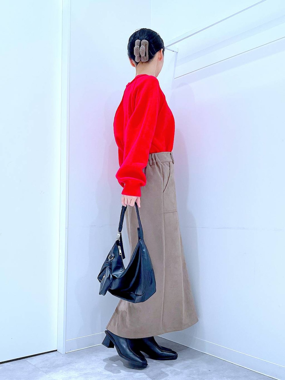 レッド系のニット/セーター、ブラック系のブーツ、ブラック系のショルダーバッグを着用したレディースの冬コーディネートの4枚目の写真