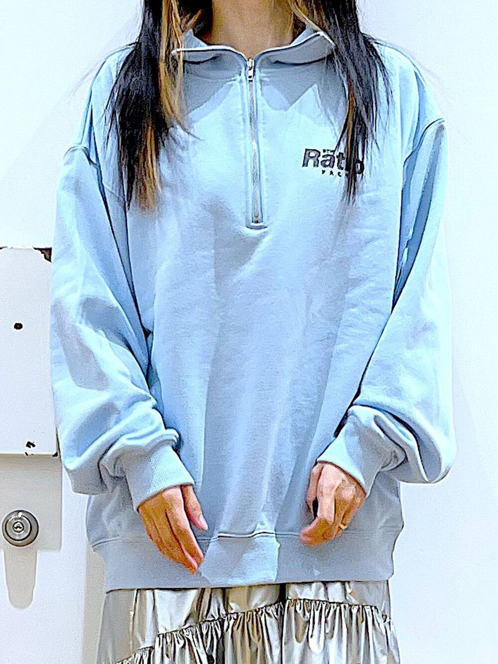 ブルー系のスウェット、シルバー系のスカート、ベージュ系のブーツを着用したレディースの春コーディネートの7枚目の写真