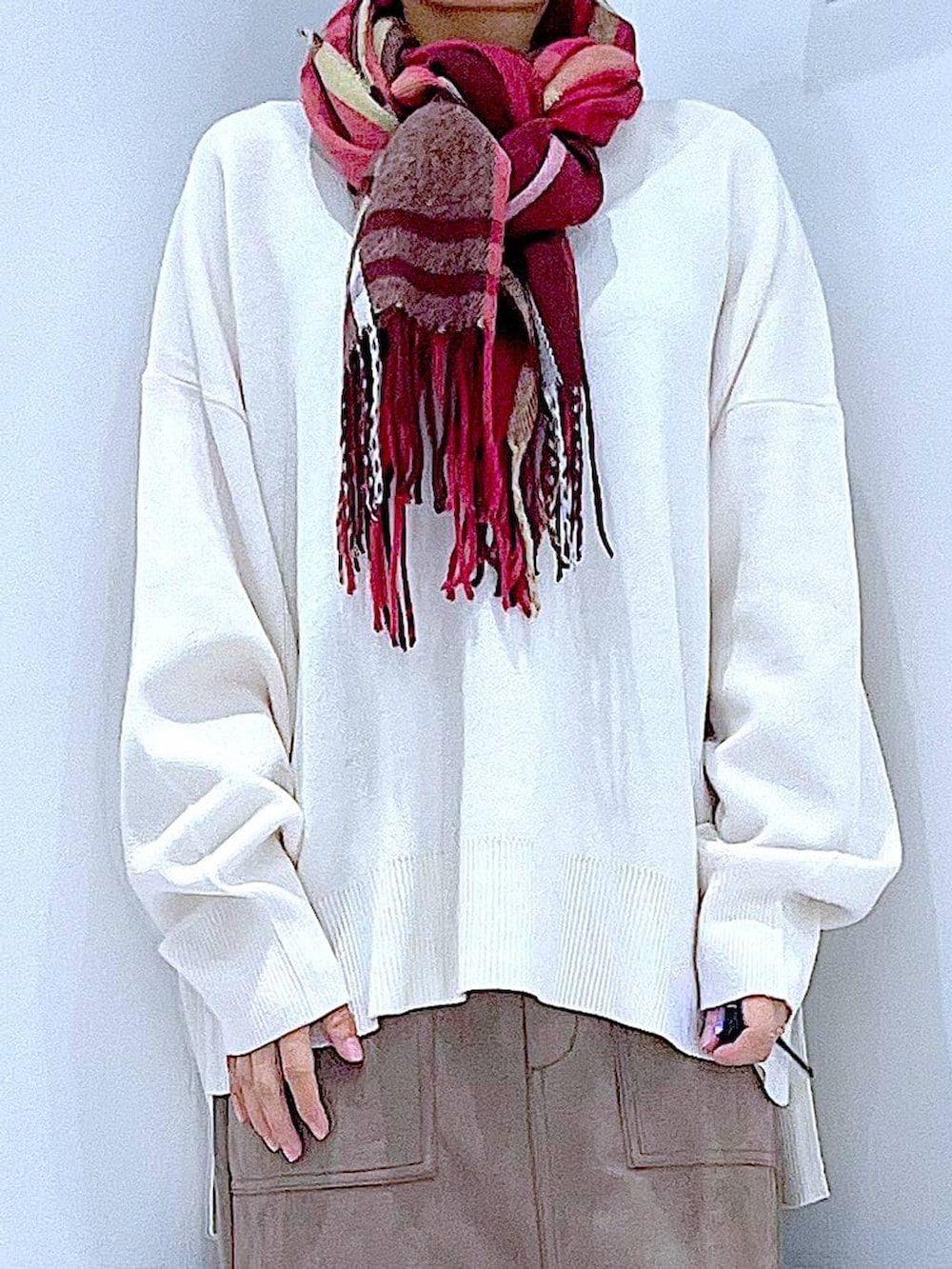 ブラック系のブーツ、ベージュ系のニット/セーター、ブラウン系のスカートを着用したレディースの秋コーディネートの8枚目の写真