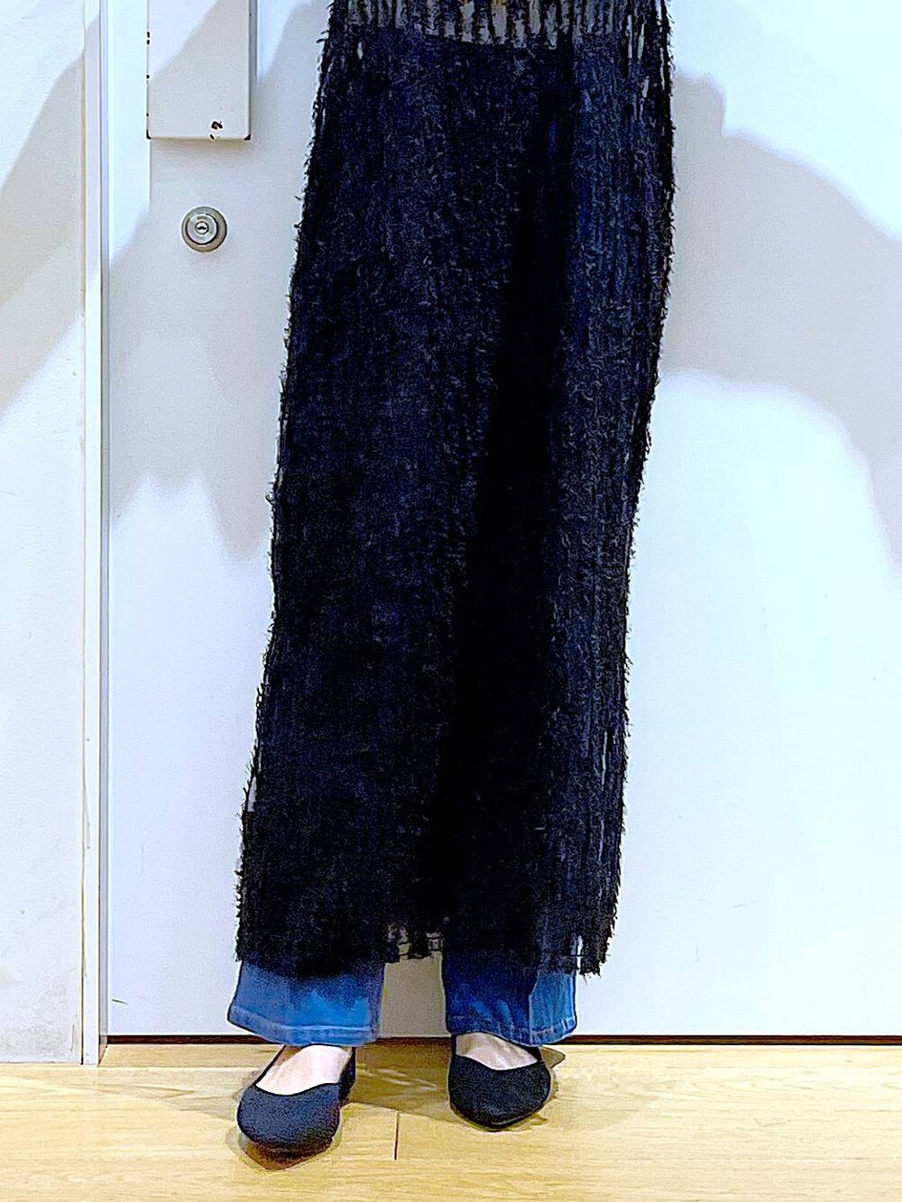 ブルー系のデニムパンツ、ブラック系のワンピース、ブラック系のパンプスを着用したレディースの春コーディネートの8枚目の写真