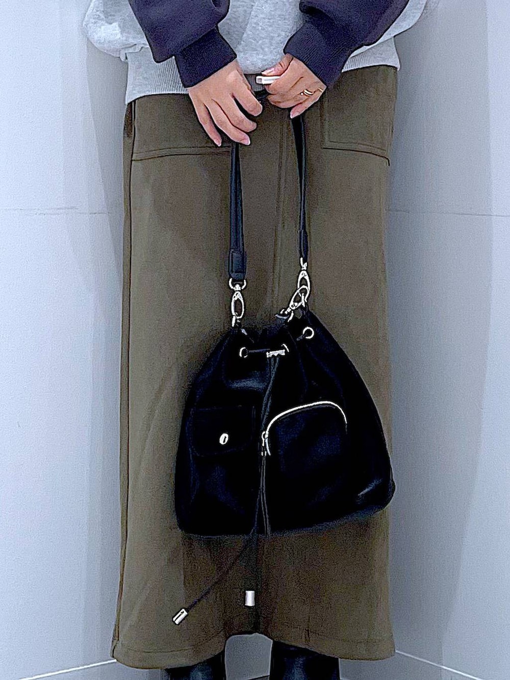 ブラック系のショルダーバッグ、グレー系のニット/セーター、ブラック系のブーツを着用したレディースの冬コーディネートの9枚目の写真