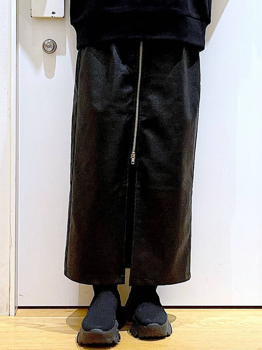 ブラック系のスカート、ブラック系のブーツ、ブラウン系のショルダーバッグを着用したレディースの冬コーディネートの8枚目の写真