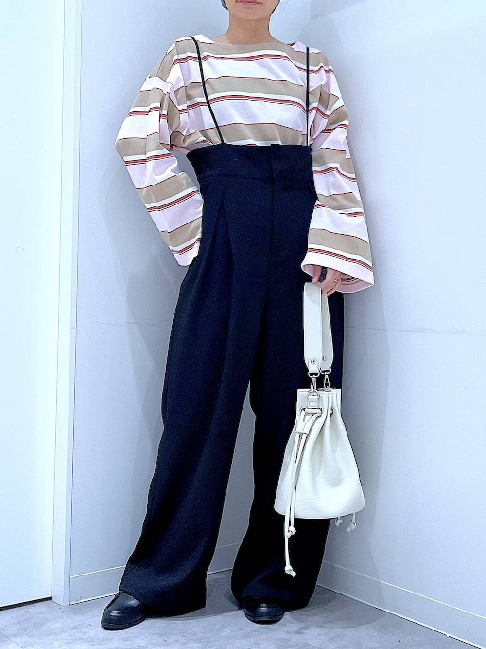 ブラック系のローファー、ホワイト系のショルダーバッグ、ブラック系のサロペット/オーバーオールを着用したレディースの春コーディネートの6枚目の写真