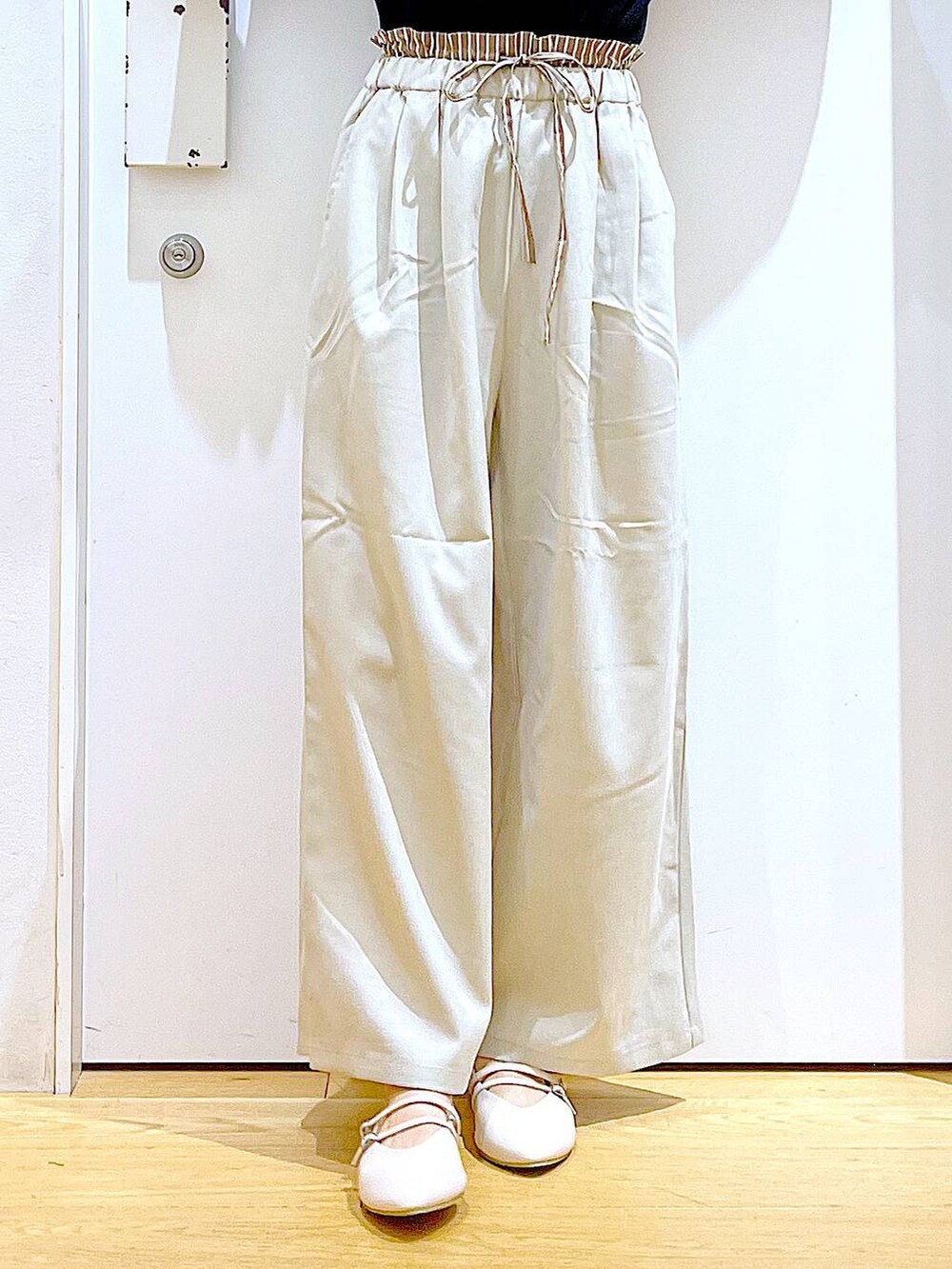 ベージュ系のトートバッグ、ホワイト系のパンプス、ブラック系のTシャツ/カットソーを着用したレディースの秋コーディネートの8枚目の写真