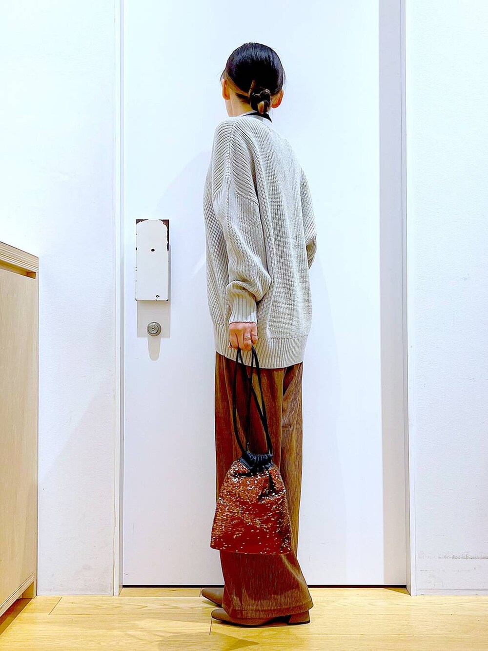 グレー系のカーディガン/ボレロ、ブラック系のニット/セーター、ブラウン系のショルダーバッグを着用したレディースの冬コーディネートの3枚目の写真