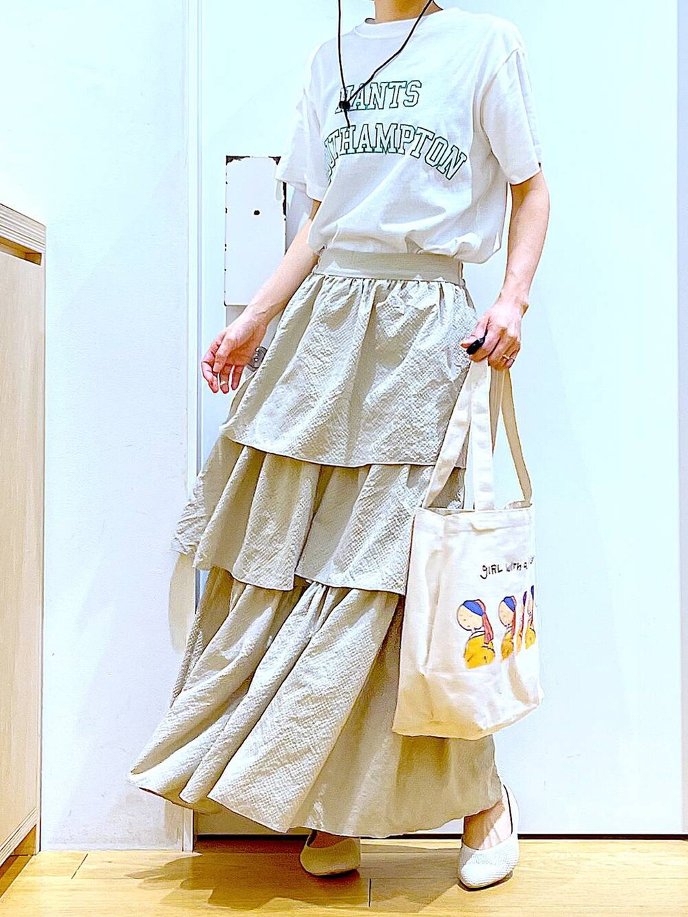 ベージュ系のスカート、ホワイト系のTシャツ/カットソー、その他のトートバッグを着用したレディースの春コーディネートの6枚目の写真