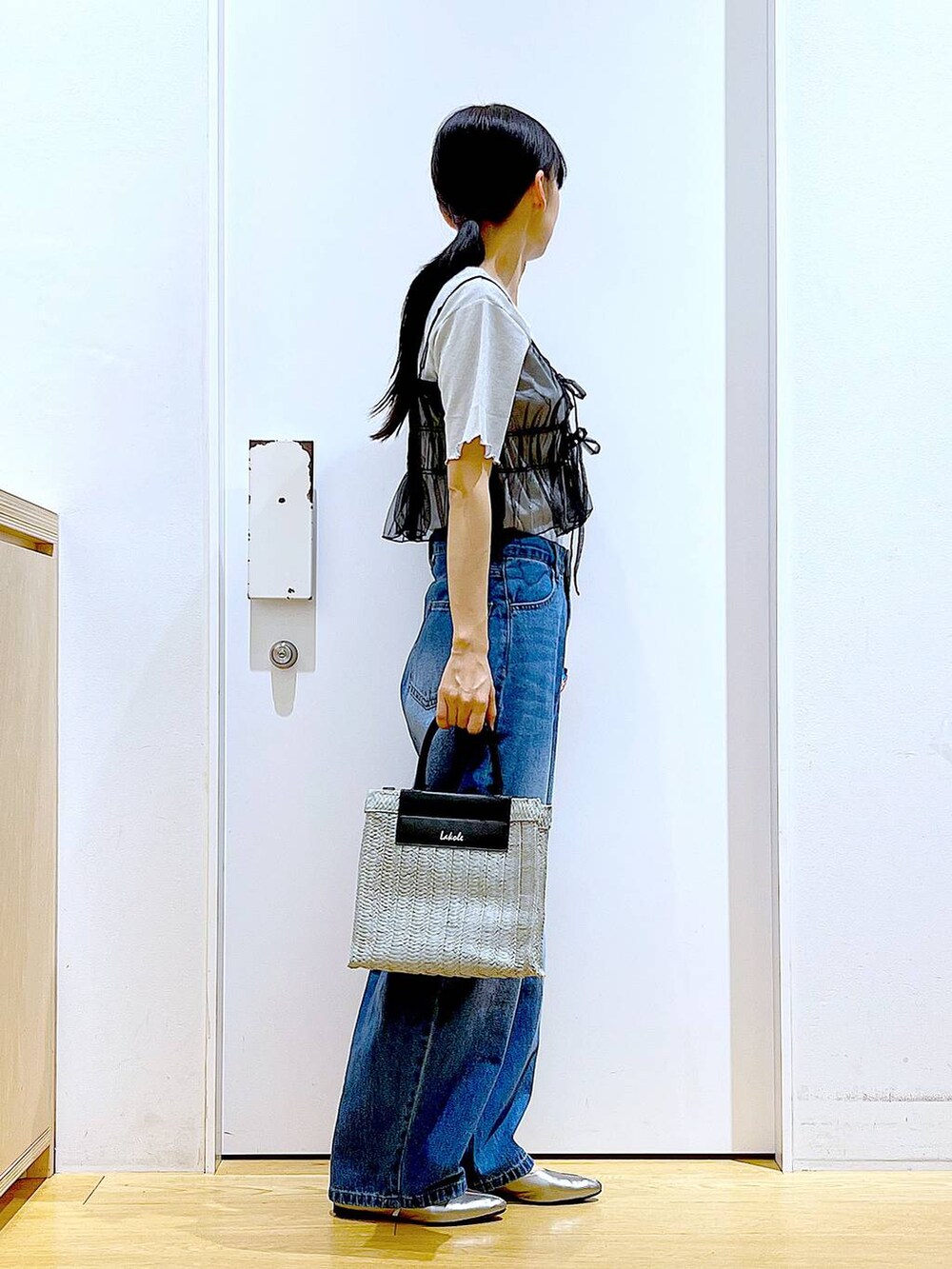 ブルー系のデニムパンツ、その他のパンプス、グレー系のショルダーバッグを着用したレディースの夏コーディネートの4枚目の写真