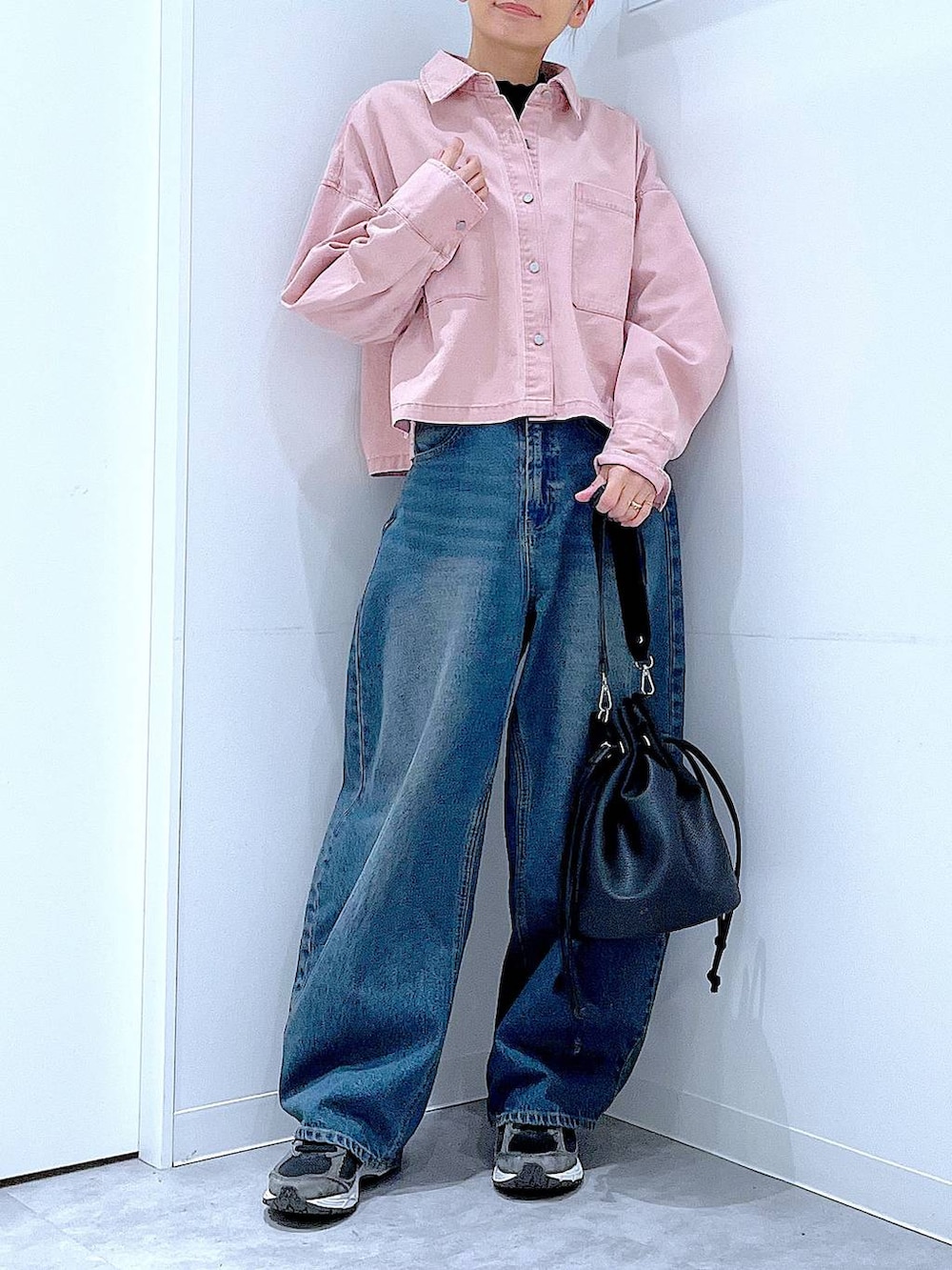 ブルー系のデニムパンツ、ピンク系のシャツ/ブラウス、ブラック系のショルダーバッグを着用したレディースの冬コーディネートの6枚目の写真