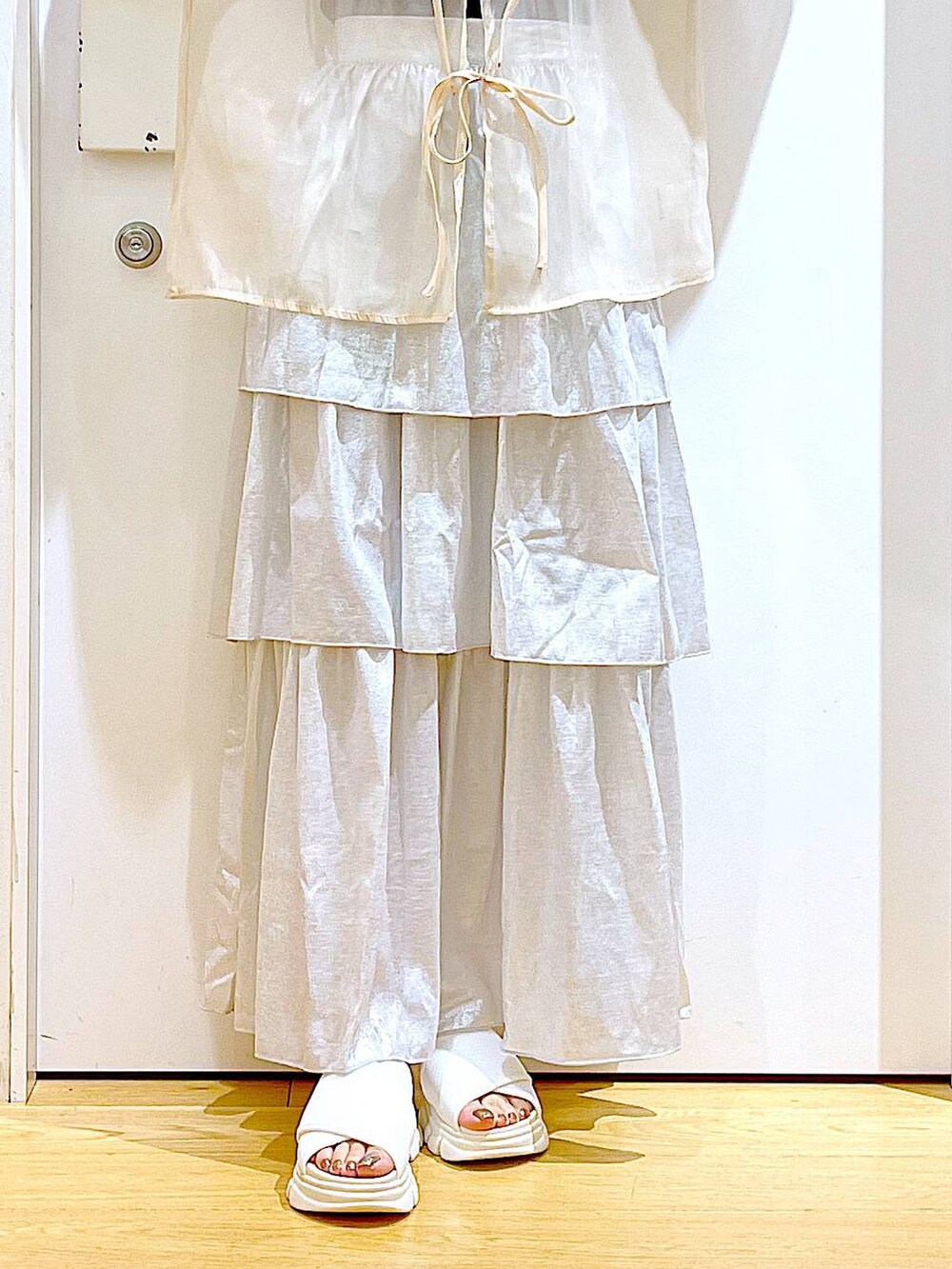 ホワイト系のサンダル、ブラック系のニット/セーター、ホワイト系のショルダーバッグを着用したレディースの夏コーディネートの8枚目の写真